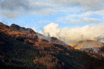 Low clouds are forming around the sunset light covered peaks of the Arrochar Alps
