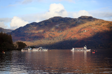 Cruise Loch Lomond boats on the opposite shore seen from Tarbet Hotel.